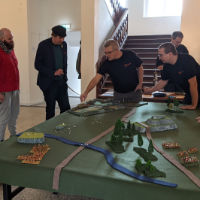 Cauldron participants standing around a battle table, playing the Battle for Safeton